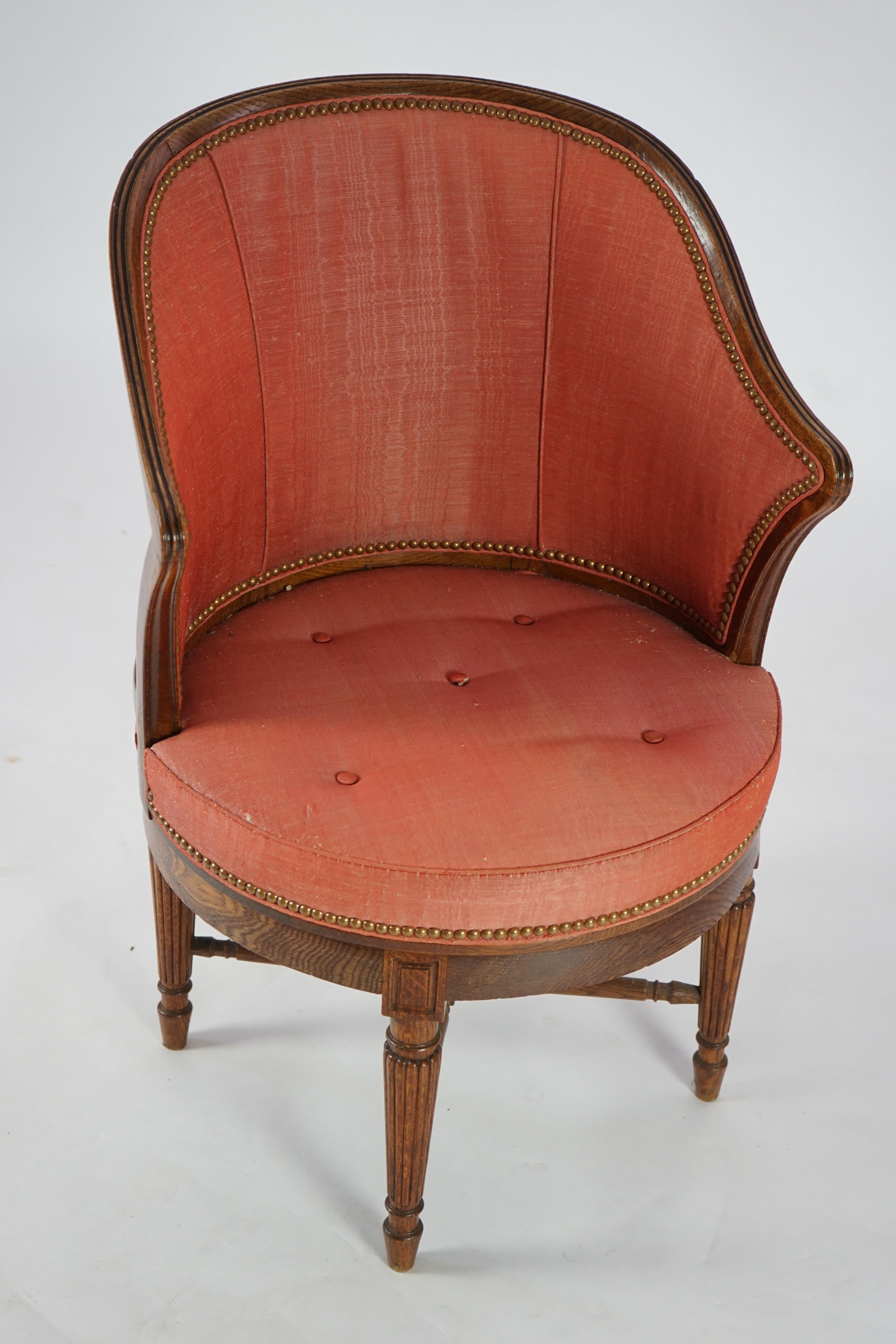 An unusual late Victorian oak revolving desk chair by Waring & Sons